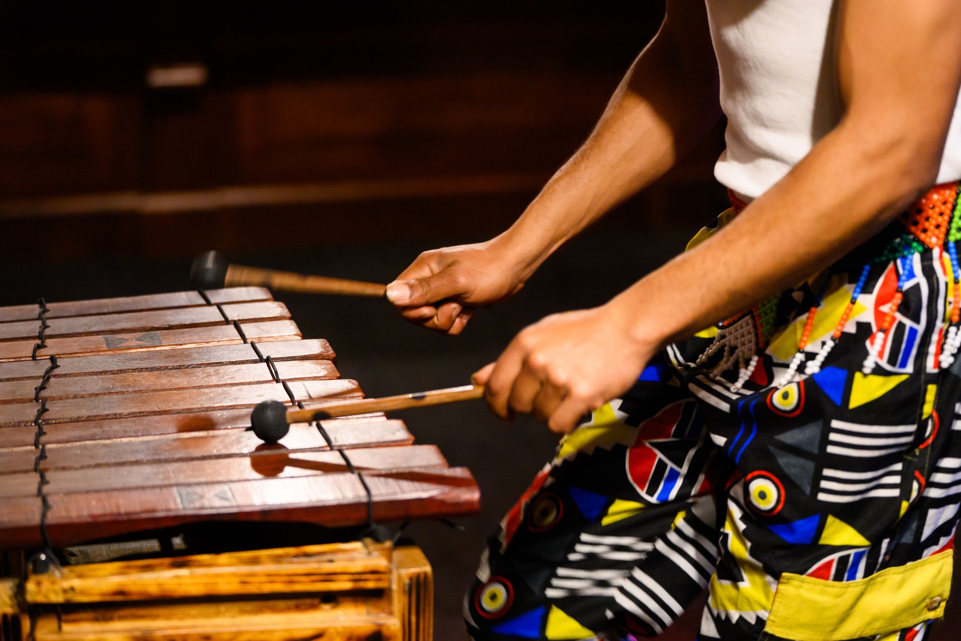Close-up of musician playing traditional wooden xylophone with mallets